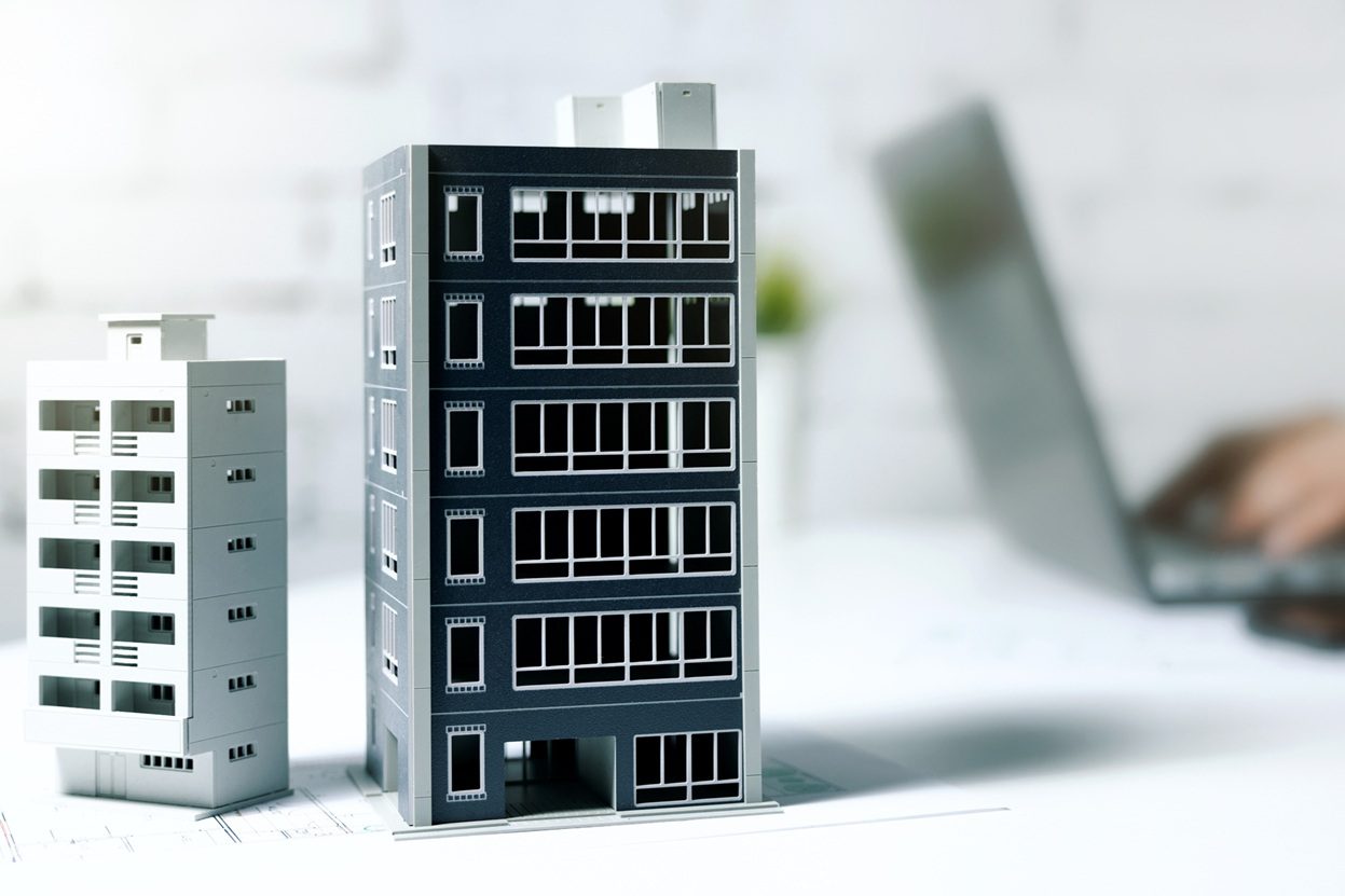 דגם של מבנה מסחרי על שולחן עבודה כחלק מתהליך איתור נכסים עם היתכנות רישוי עסקים