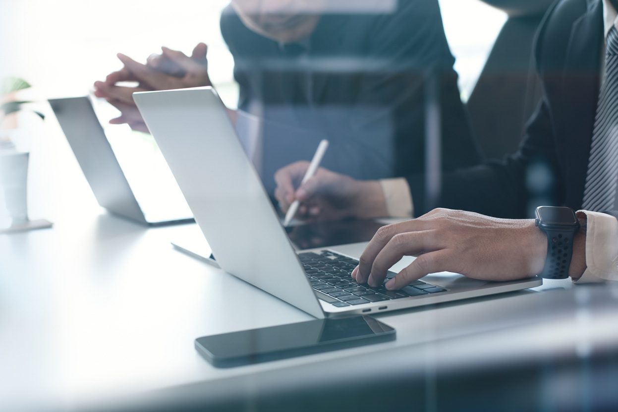 אנשי מקצוע מבצעים בדיקת היתכנות רישוי עסקים לנכס באמצעות מחשב ומסמכים