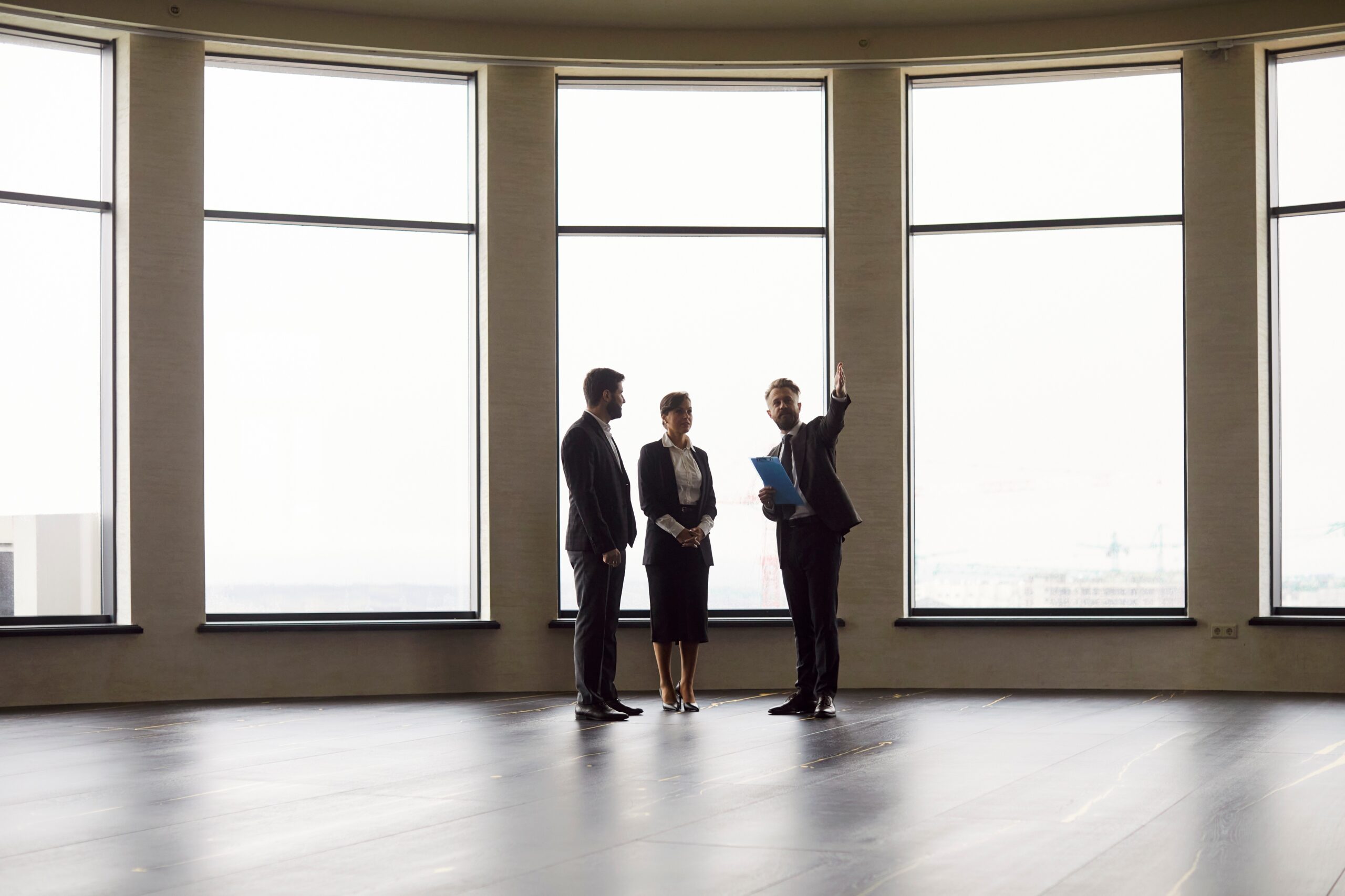 מתווך מציג נכס מסחרי לשני לקוחות כחלק מבדיקת היתכנות רישוי עסקים למתווכים